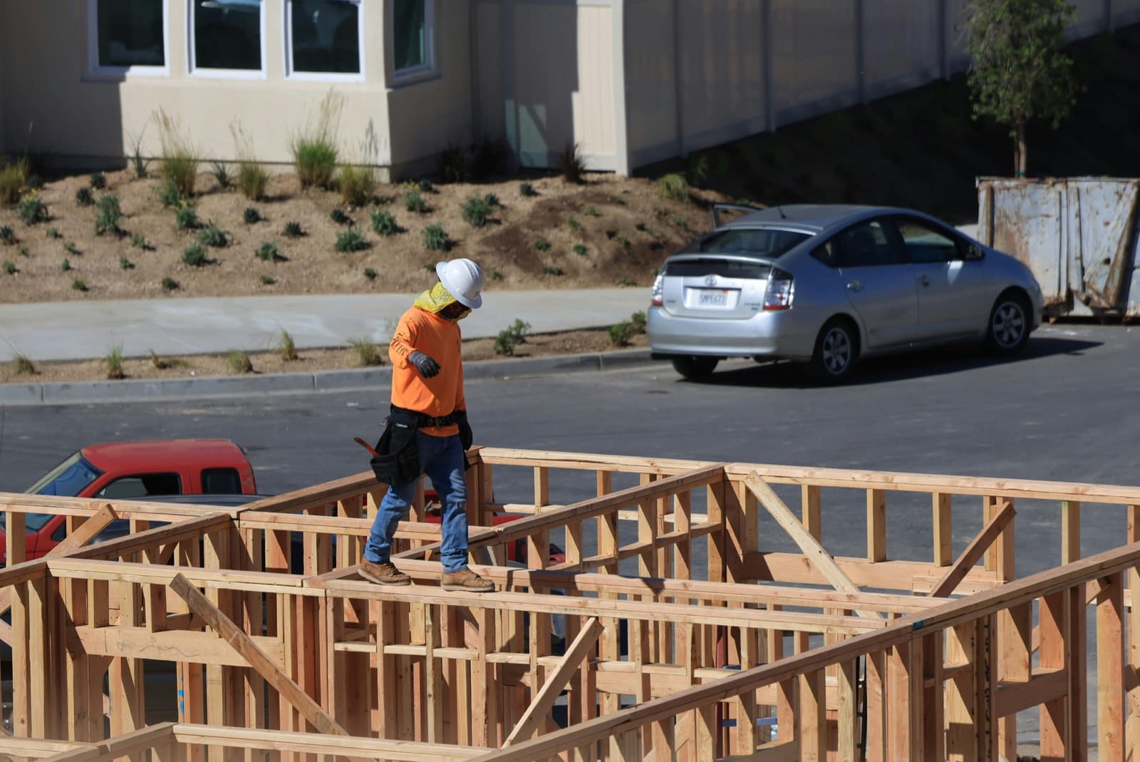 Carpenter framing a residential wall on a job site