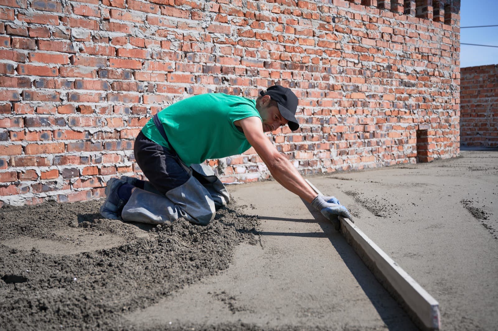 Mason laying brick on a residential exterior wall