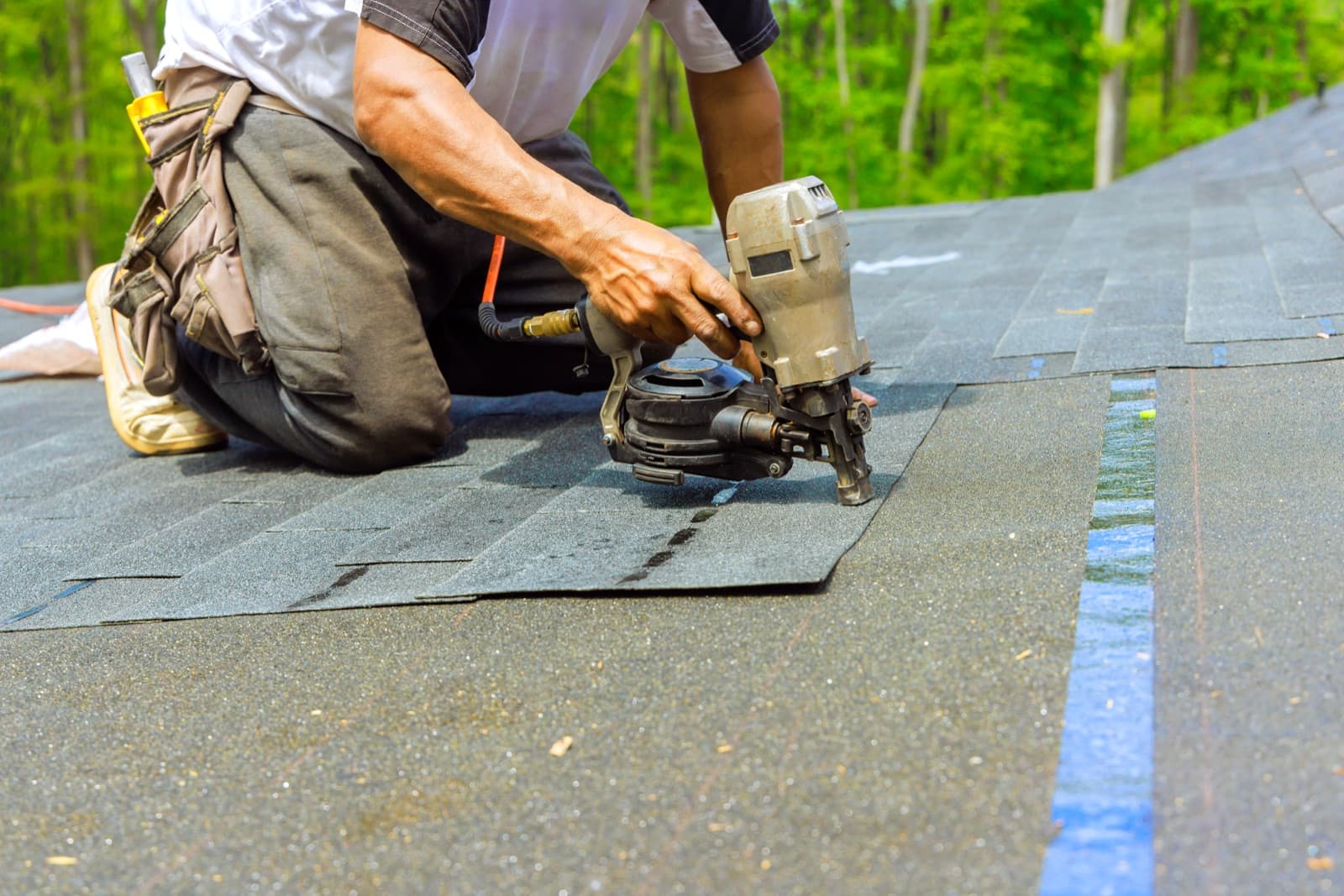 Roofer installing asphalt shingles on a residential home