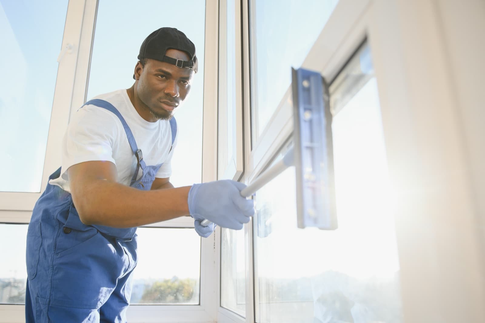 Window cleaner washing exterior glass from a ladder on a residential home
